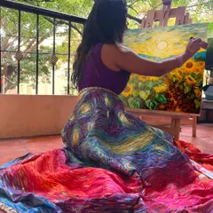 Here I am, lost in the process of painting a sunflower field against a sunset, bringing the vision for my lehenga to life stroke by stroke on an easel in my balcony.