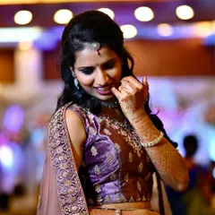 Another candid portrait of the bride, capturing her natural smile and the intricate details of her reception lehenga and henna.
