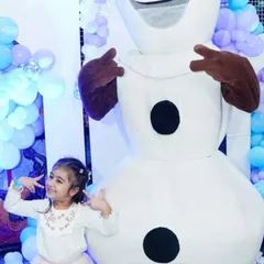 A little guest strikes a cool pose with the Olaf mascot at a 'Frozen' themed birthday party.