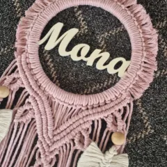 A closer look at the 'Mona' name hanging, showing the detail in the macrame knots and the elegant script of the name.