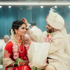 A beautiful moment during the wedding ceremony where the groom is applying sindoor to the bride.
