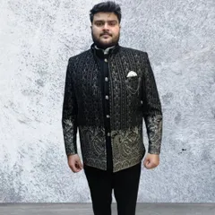 This is our designer Jodhpuri shrug, a modern take on the classic suit. The black and gold embroidered jacket is worn over a kurta, creating a layered, regal look.