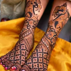 A bold and striking foot design featuring large peacock motifs that curve gracefully along the feet, complemented by a dense floral pattern on the toes.