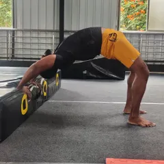 This student uses a block to support his backbend, allowing him to hold the pose longer and work on his form.