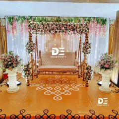 A beautiful baby shower setup featuring a floral-decorated swing and a floor covered with a traditional kolam or rangoli pattern, creating a perfect blend of elegance and tradition.