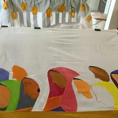 Here is a saree in the process of being painted. One end features a motif of women's profiles, while the other is being prepared for a cascade of yellow tulips, all painted by hand.