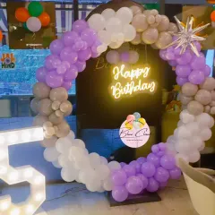 A modern and stylish balloon ring in purple, grey, and white. This setup includes a neon "Happy Birthday" sign and a large marquee number '5', perfect for a chic party.