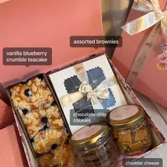 Here’s what goes inside one of my popular hamper sizes. You get a vanilla blueberry crumble teacake, assorted brownies, chocolate chip cookies, cheddar cheese crackers, and a daisy candle.