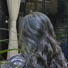 A still from the fade hair color video, capturing the soft waves and the way the silver highlights are woven through the hair.