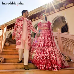 Another Incredible India feature, this one highlighting a couple in vibrant red outfits against the stunning architecture of a Rajasthan palace.