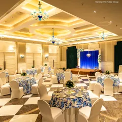 A stage setup within my banquet hall, perfect for a wedding ceremony, musical performance, or awards presentation. The rich blue backdrop and elegant lighting ensure the focus remains on your event's main feature.