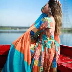 A side profile of the model in the Anarkali, capturing the flow of the dress against the river backdrop.