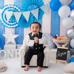 Dressed in his birthday best, this little gentleman is all smiles and claps, ready for his cake smash party to begin.