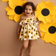 A heart full of sunshine! This toddler's sunflower-themed shoot is bright, cheerful, and full of happy energy. The paper flowers create a beautiful, textured backdrop.