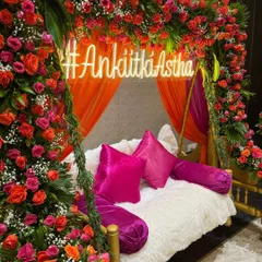 For a modern and trendy Mehendi, I designed this beautiful seating area. It features a floral-draped swing, plush cushions in bold pink, and a custom neon hashtag sign for the couple. It’s a perfect spot for the bride and for guests to take photos.