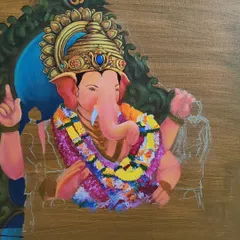 A further stage of the Ganesha painting, with more color and form added to the deity's garland and crown. This demonstrates the careful process of developing a complex spiritual artwork.