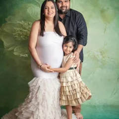 Such a beautiful family portrait. The mom-to-be looks stunning in a white gown, and her daughter is so happy to be part of this special memory.