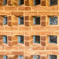 We believe in finding beauty in the details. This is a close-up of a custom jaali wall, where we used angled mud blocks and glass inserts to create a beautiful pattern that plays with light and privacy, casting unique shadows throughout the day.