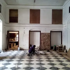 The hall during the restoration process, with the floor partially laid and walls stripped back, revealing the original brickwork.