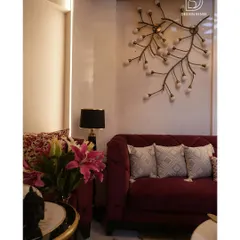 A closer look at the details in our "5-star hotel" project, highlighting the custom branch-like wall light fixture and the plush, deep-red velvet sofa that adds a pop of color and luxury.