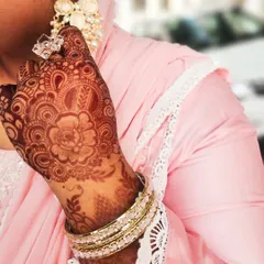 A beautiful floral mandala stain, perfect for an Eid celebration or any festive event. The design is complemented by elegant jewelry and a lovely pink outfit.