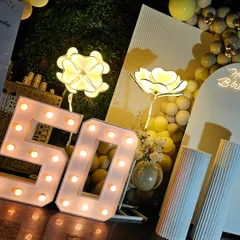Highlighting the large, light-up '50' marquee numbers and illuminated flower props. These elements add a touch of glamour and are perfect for photos.