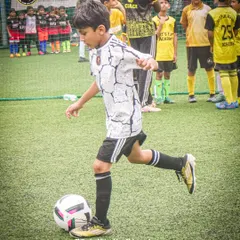 In the heat of the game, every touch counts. A young player demonstrates perfect form while controlling the ball.