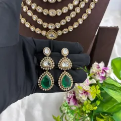 A close-up of the earrings from the emerald layered necklace set.