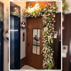 We can create designs that fit any space, like this asymmetrical L-shaped arrangement for an apartment entrance. The soft colors of the pink and white roses provide a sophisticated and modern welcome.