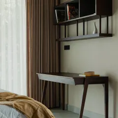 This minimalist study area features a sleek, modern writing desk and a matching floating bookshelf. Crafted from dark wood, this set offers a stylish and clutter-free workspace.