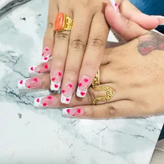 A playful and romantic design with encapsulated hearts. This clear nail set features a French tip, silver glitter, and tiny red hearts that appear to float inside the nail.