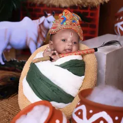 A newborn version of our Little Krishna theme. This tiny, swaddled baby holds a flute, surrounded by props like a cow figurine and matkis for a truly special first Janmashtami photo.
