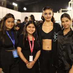 A proud moment for our students, posing with a model after successfully creating her avant-garde runway look. These experiences build both their portfolio and their confidence as professional artists.