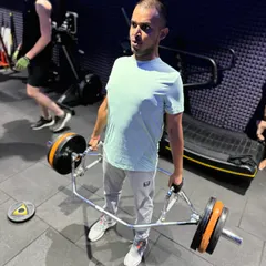 The trap bar deadlift is a fantastic alternative to the conventional deadlift, as it puts less stress on the lower back. This client is shown at the top of the movement, maintaining a strong, upright posture.
