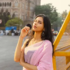 The yellow barricade adds a pop of color and a distinctly urban feel to this elegant saree portrait, with the historic CSMT station in the background.