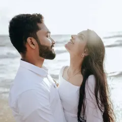 A sun-kissed photo of a couple on the beach, their faces lit up with joy and the warmth of the sun.