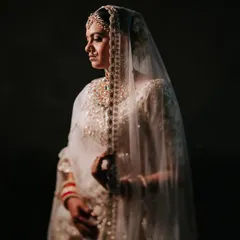 A classic bridal portrait, bathed in soft, golden light. The bride's serene expression and the delicate veil create a timeless and ethereal mood.