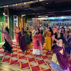 The entire studio filled with dancers learning a Garba routine. I structure my workshops to handle large groups, breaking down steps so everyone can follow along and dance in sync.
