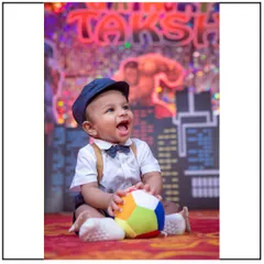 A fun and energetic superhero-themed cake smash or first birthday session. The colorful city backdrop and happy expression make for a fantastic memory.
