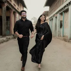 A happy, energetic shot of the couple running hand-in-hand. The historic architecture of the street provides a beautiful, textured backdrop.