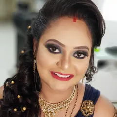 This client wanted a dramatic look for her reception. I created a bold black and gold smokey eye with a bright red lip, complemented by a curly side-swept hairstyle.