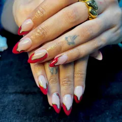 Fiery elegance with a twist. This abstract design uses a vibrant red polish over a neutral base, with a flowing gold chrome line accentuating the curves for a dramatic and artistic effect on long stiletto nails.