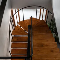 This custom staircase is a centerpiece, not just a utility. I replaced a bulky concrete structure with this lighter, open-riser design in metal and solid timber, allowing sunlight to flow freely through the duplex home.