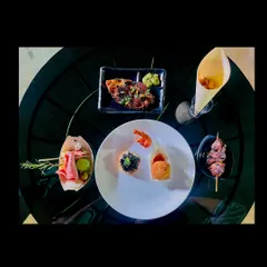 A curated plate of gourmet appetizers. This top-down view shows a variety of my offerings, including pizza, skewers, fried shrimp, and canapés, demonstrating the diversity of my menu.