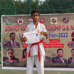 Shiva Kumar on the podium after winning a gold medal at the District Karate Championship G.B. Nagar Sub-Junior Selection 2022.
