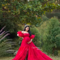 Surrounded by lush greenery, this portrait in a stunning red gown feels both powerful and serene.