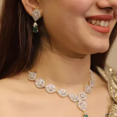 A classic diamond-look necklace with a single emerald drop. This piece is versatile and can be paired with both traditional and contemporary outfits.