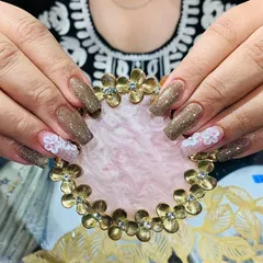 This design combines a rich, glittery brown polish with accent nails featuring delicate 3D white flowers. It's a great example of a balanced and elegant embellished set.