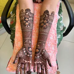 This design features majestic peacocks and palace jharokhas on the forearms, with intricate patterns filling the hands. It's a classic example of royal-themed bridal henna.