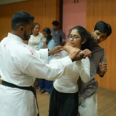 We prepare you for worst-case scenarios, including weapon-based threats. Here, an instructor demonstrates a practical technique to defend against a knife attack, focusing on control, disarming, and creating distance.
